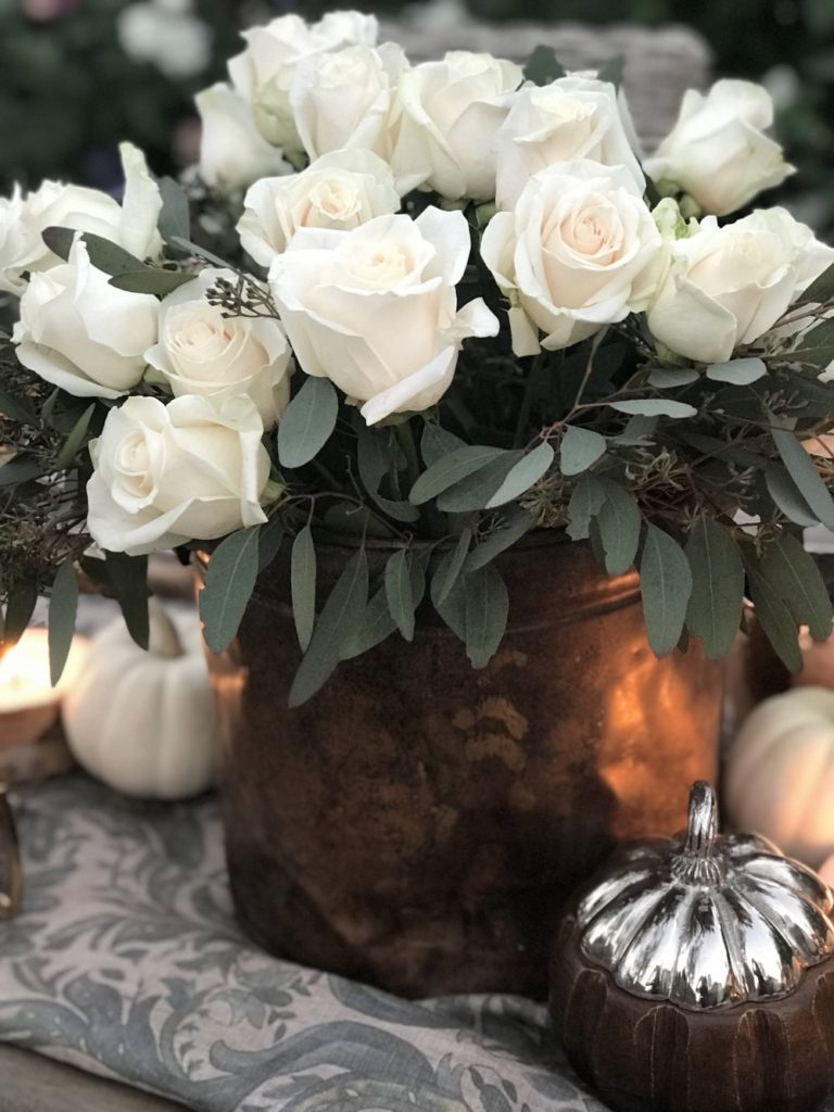 White rose centerpiece in copper bucket