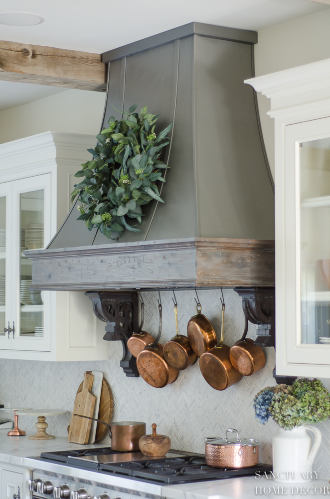 5 Minute Fall Decorating Tips-White country kitchen with pendant lights and glass front cabinets. White marble countertops-Zinc Range hood