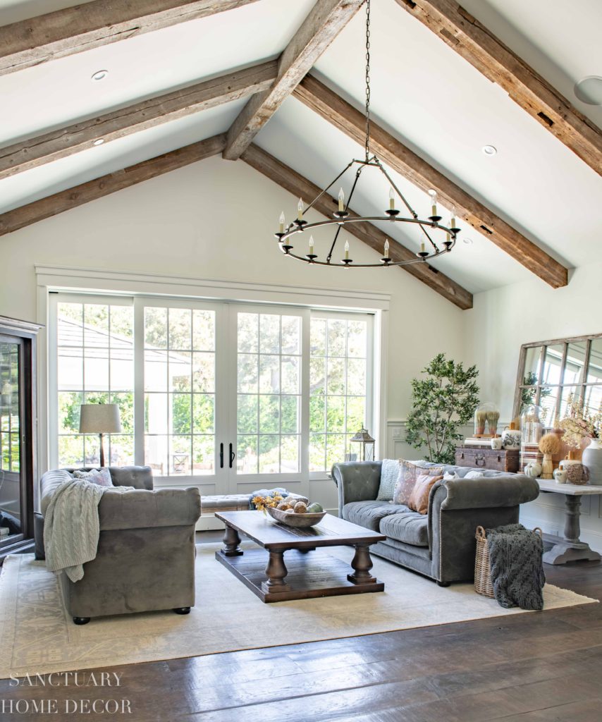 Rustic Living room with wood beams and wall of windows.  Benjamin Moore Swiss Coffee paint-4-simple-fall-decorating-ideas-for-any-room