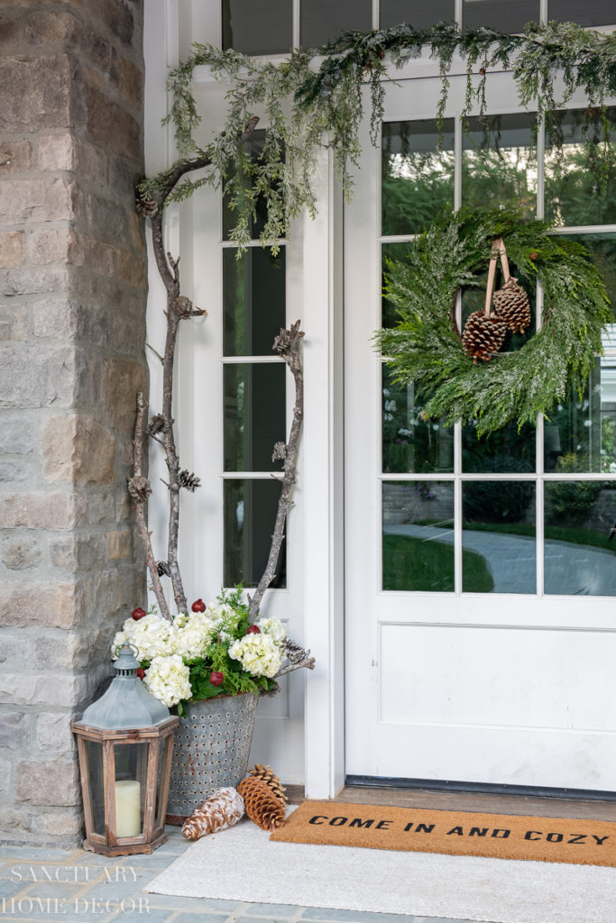 Welcome this winter season with this classic pine cone door swag