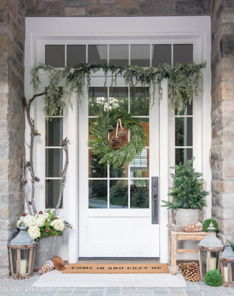 Welcome this winter season with this classic pine cone door swag